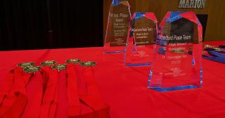 awards and medals for first, second, and third place winners on a table