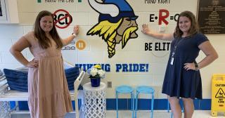 Twins, Brittany and Cailey Lower, posing for photo in classroom