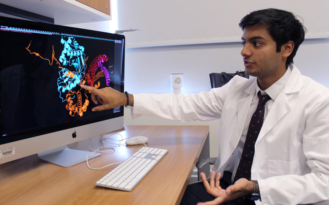 Biology major Shayaan Rasheed next to his research