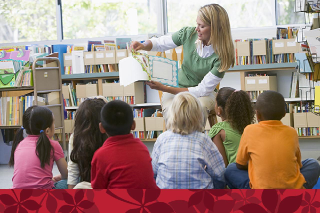 teacher reading book to six young students