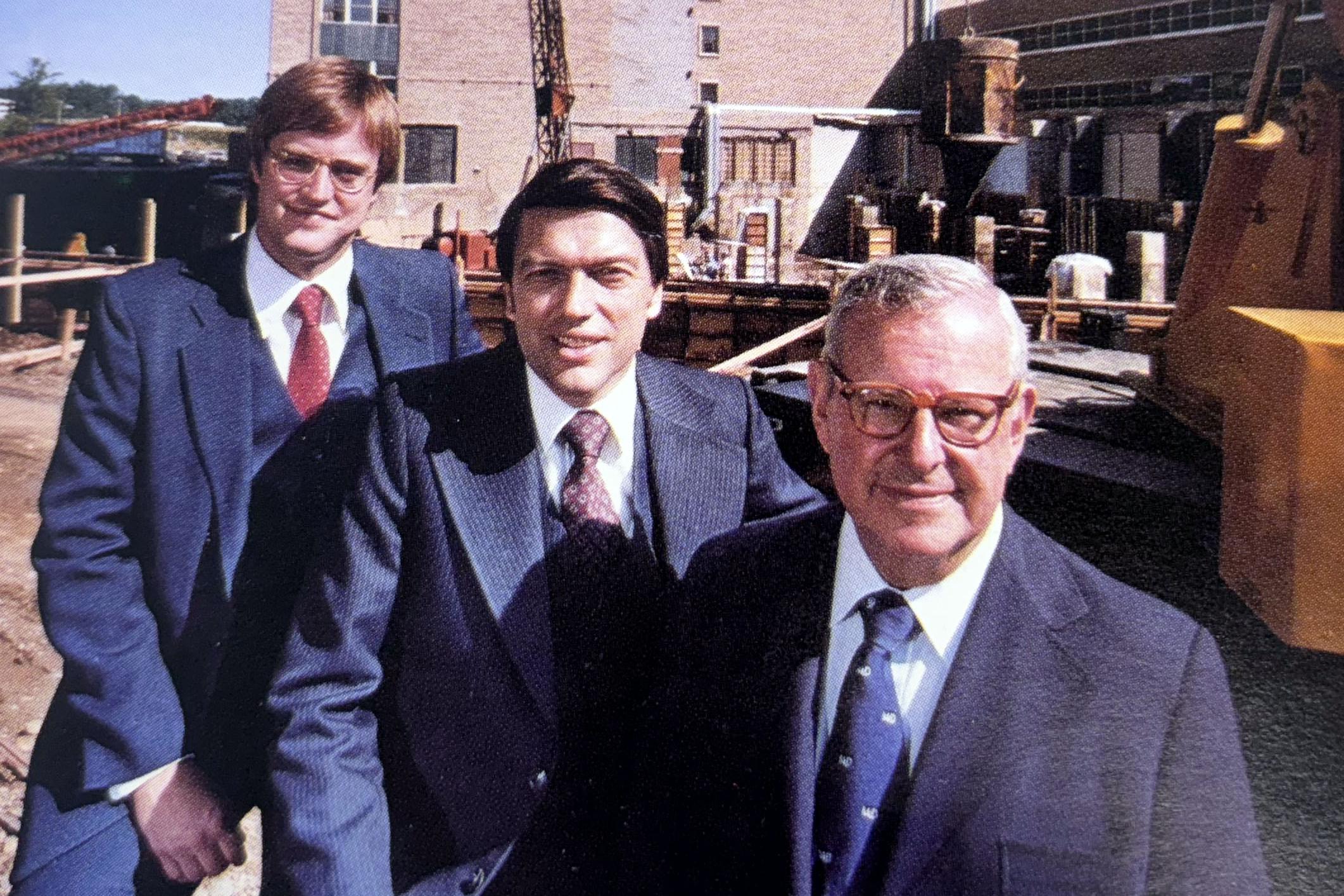 three men in suites at construction project