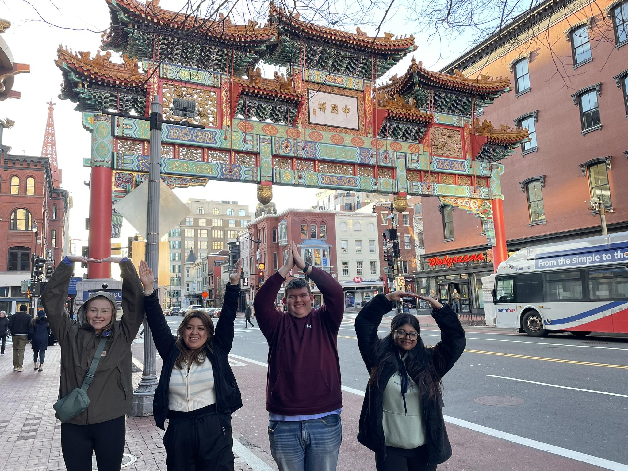 Group of 4 arms up in china town in Washington DC