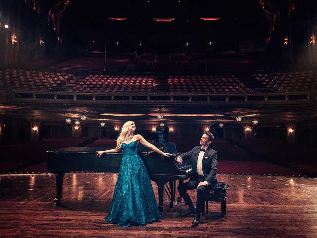 man and woman in dance pose on stage in front of piano