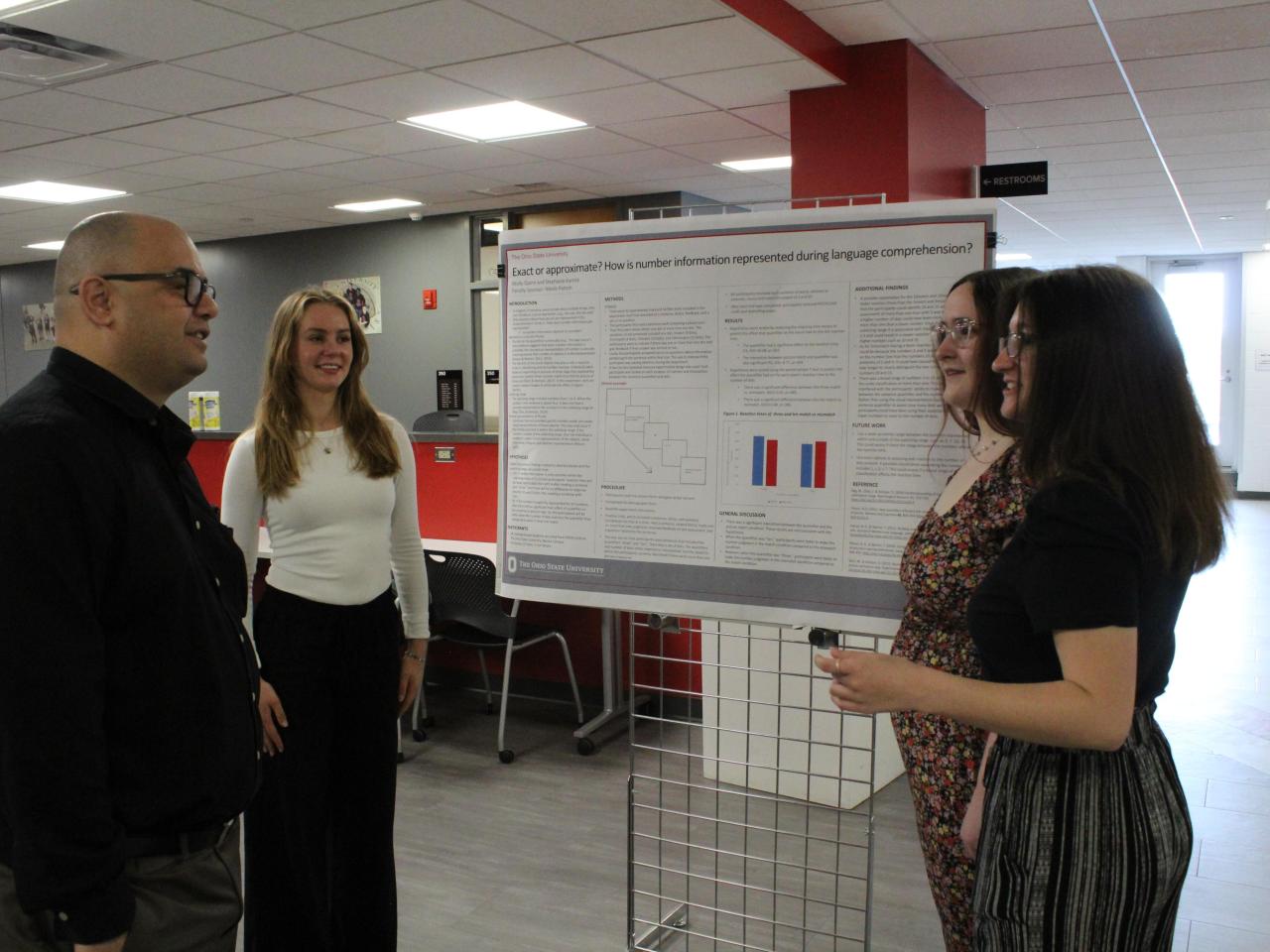 student present their research poster to a faculty member