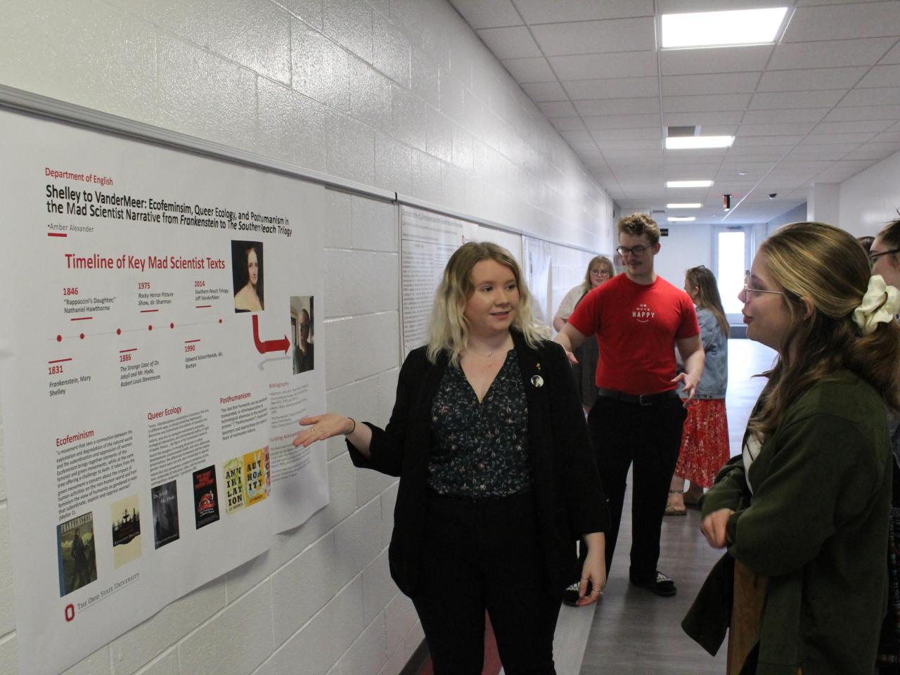 Student presents their research poster to faculty
