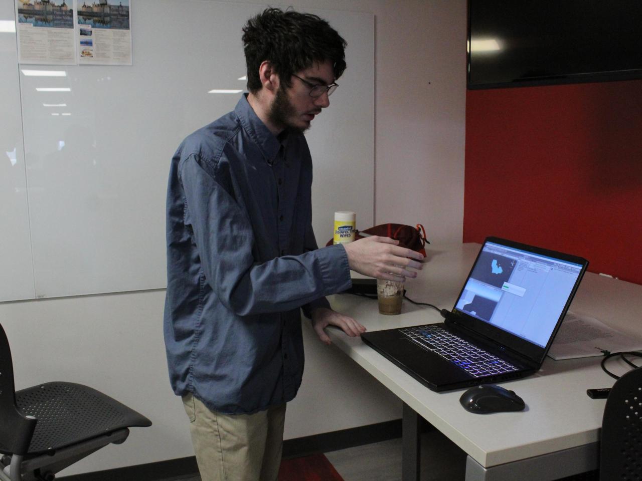 student presenting research from his computer