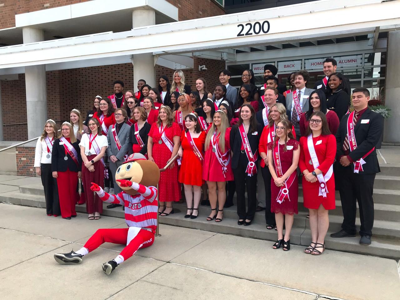 Group with mascot outside building steps