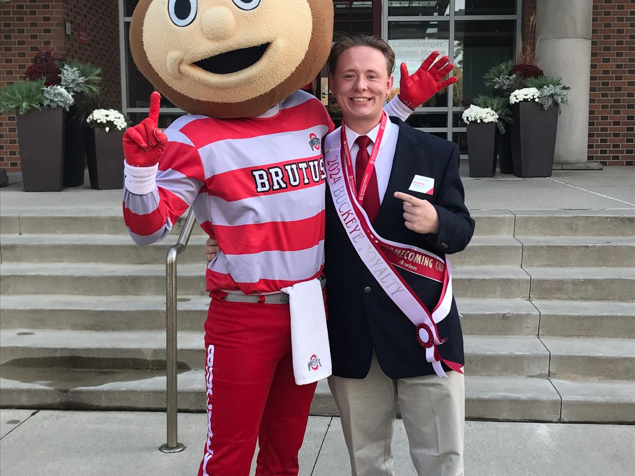 Brutus mascot and man in suit pose on steps