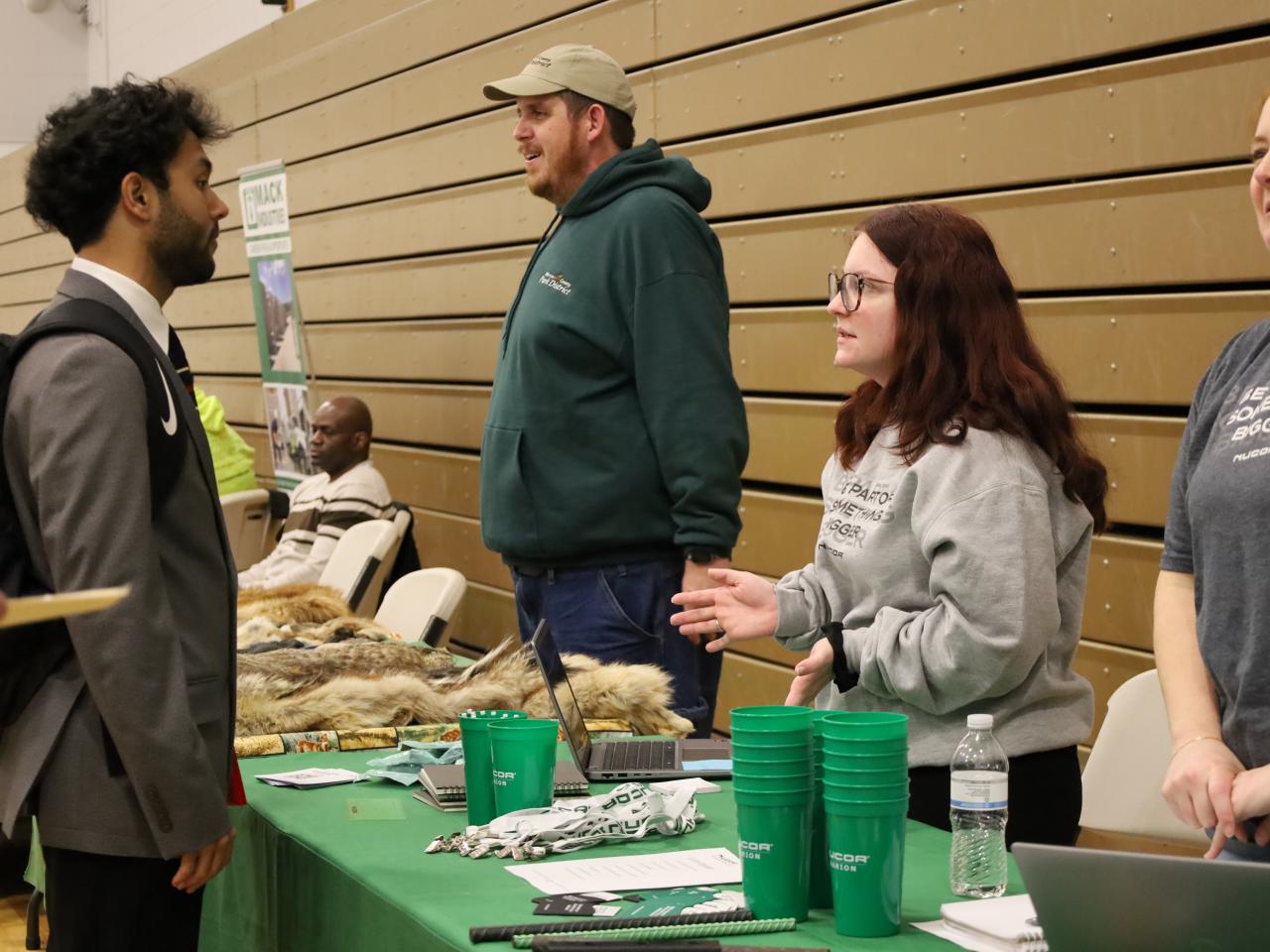 man in suit speaking with potential employer at job fair