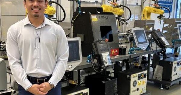 man standing next to engineering manufacturing machine