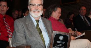 Dr. Richard A. Bradley posing with the Ralph Howard Service Award