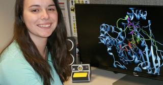 Rachel Hopper posing with computer showing Molecular Modeling
