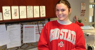 Young woman in college sweatshirt smiling in office environment