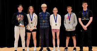 six middle school students with medals around neck