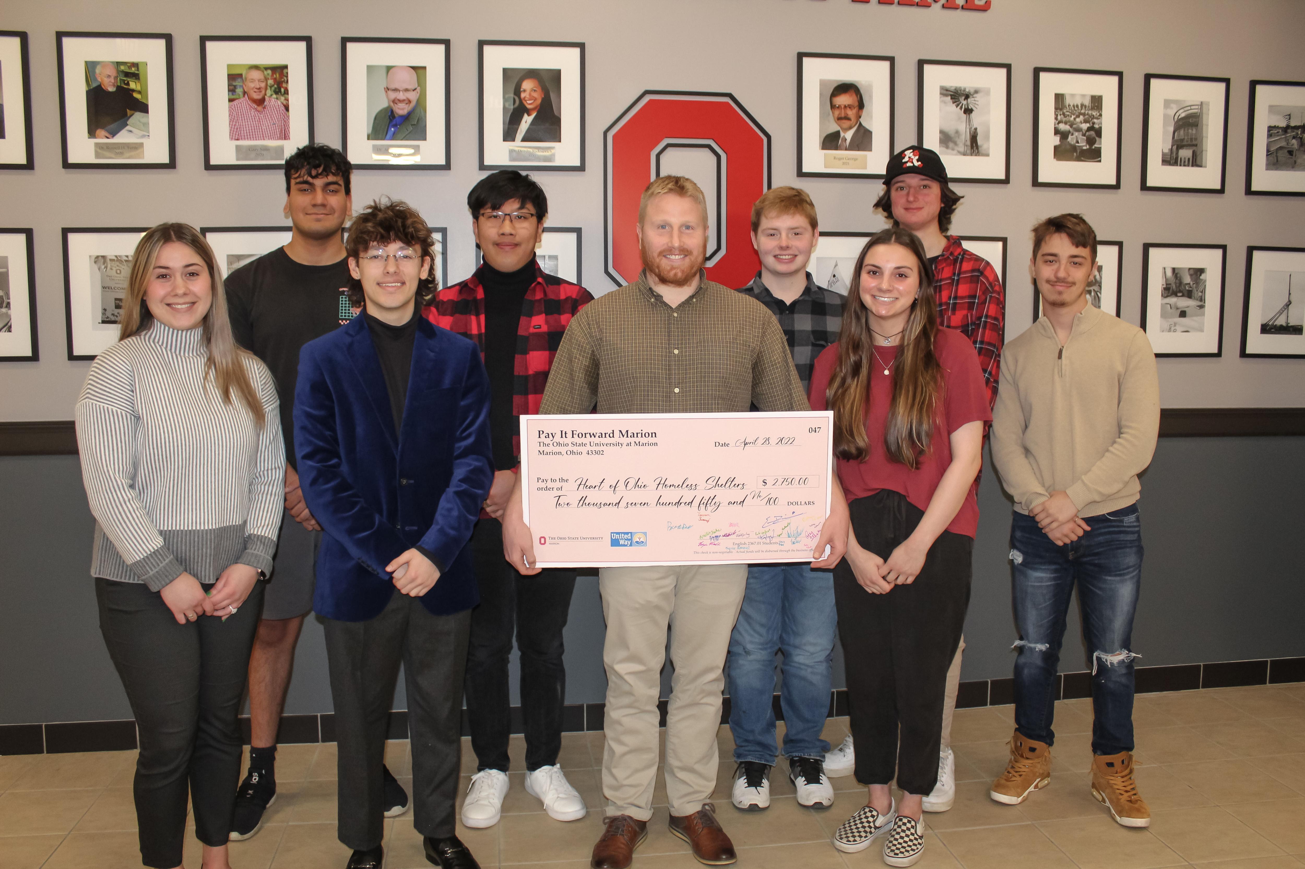 students posing with recipient of one of the checks