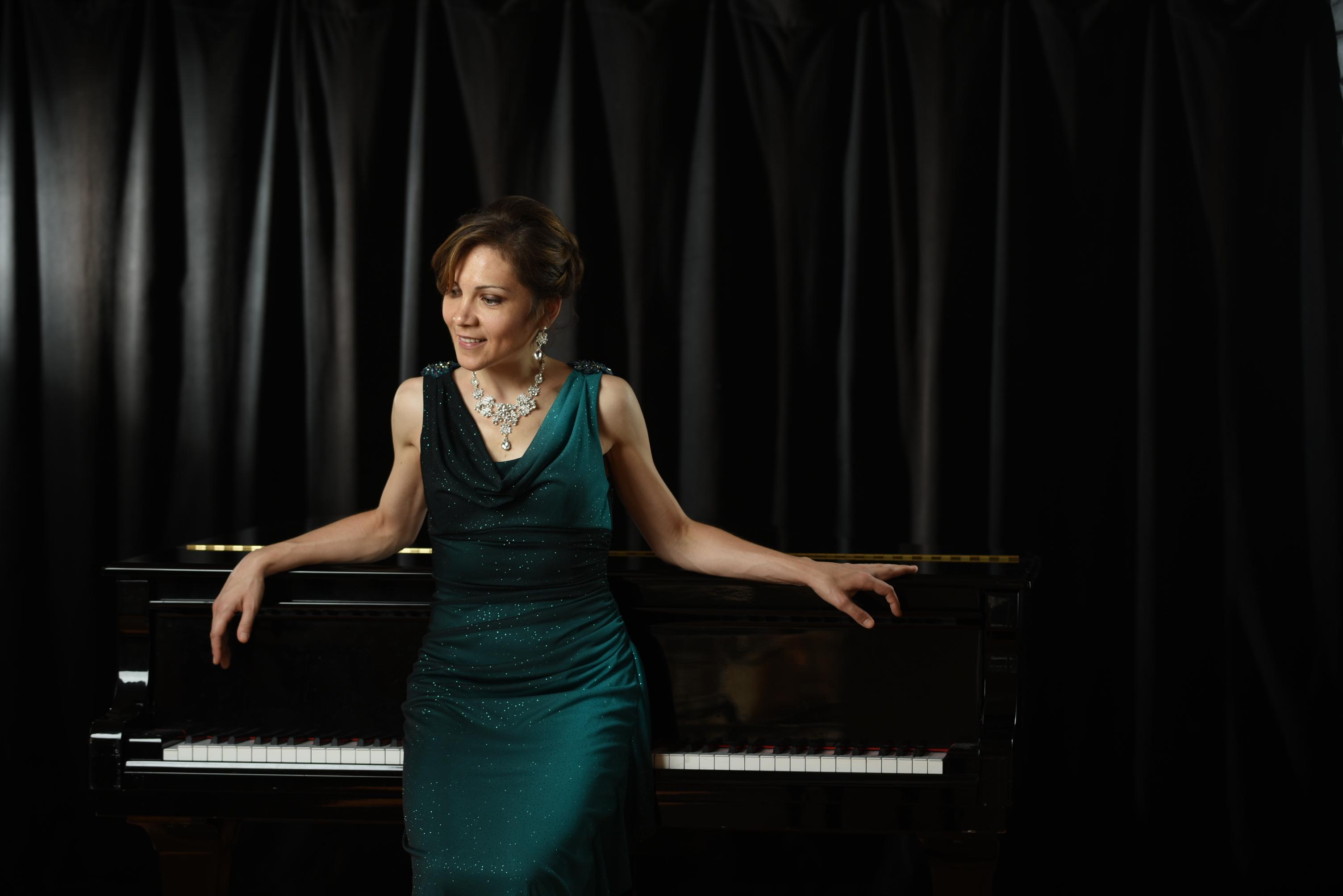 pianist in green dress posing on piano