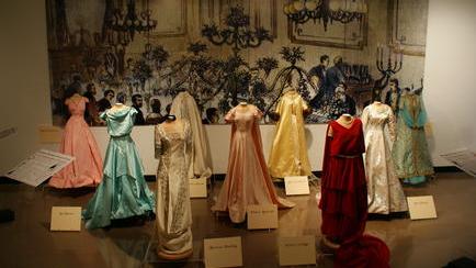 Old ballroom gowns hanging on forms in a gallery