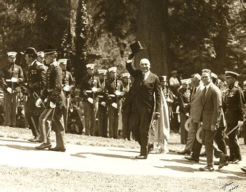 Warren G. Harding waving at camera with top hat in hand