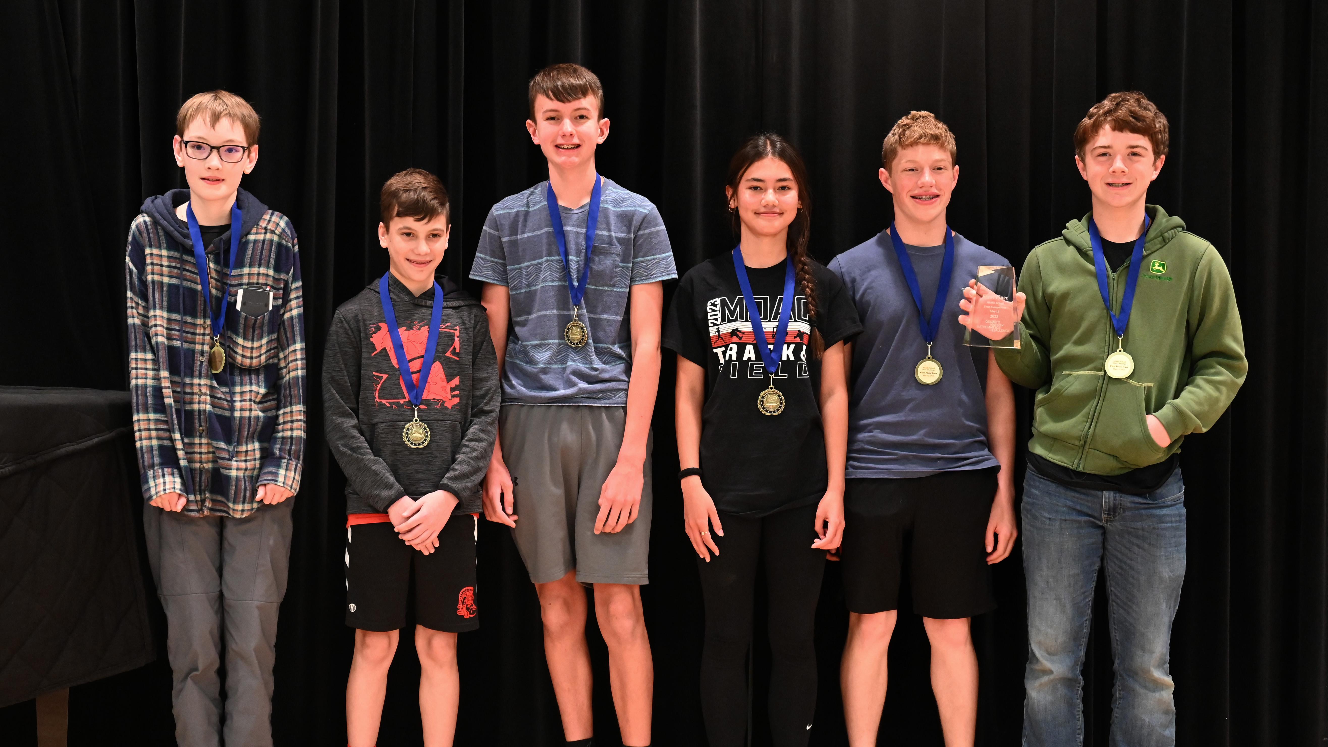 Six middle school students pose with award