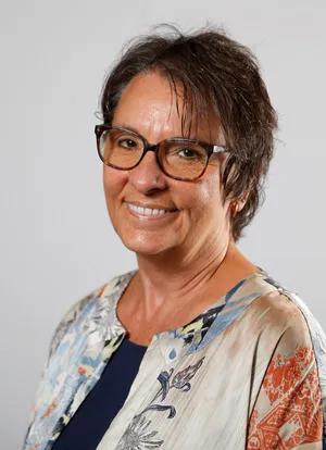 woman with dark hair and glasses smiline