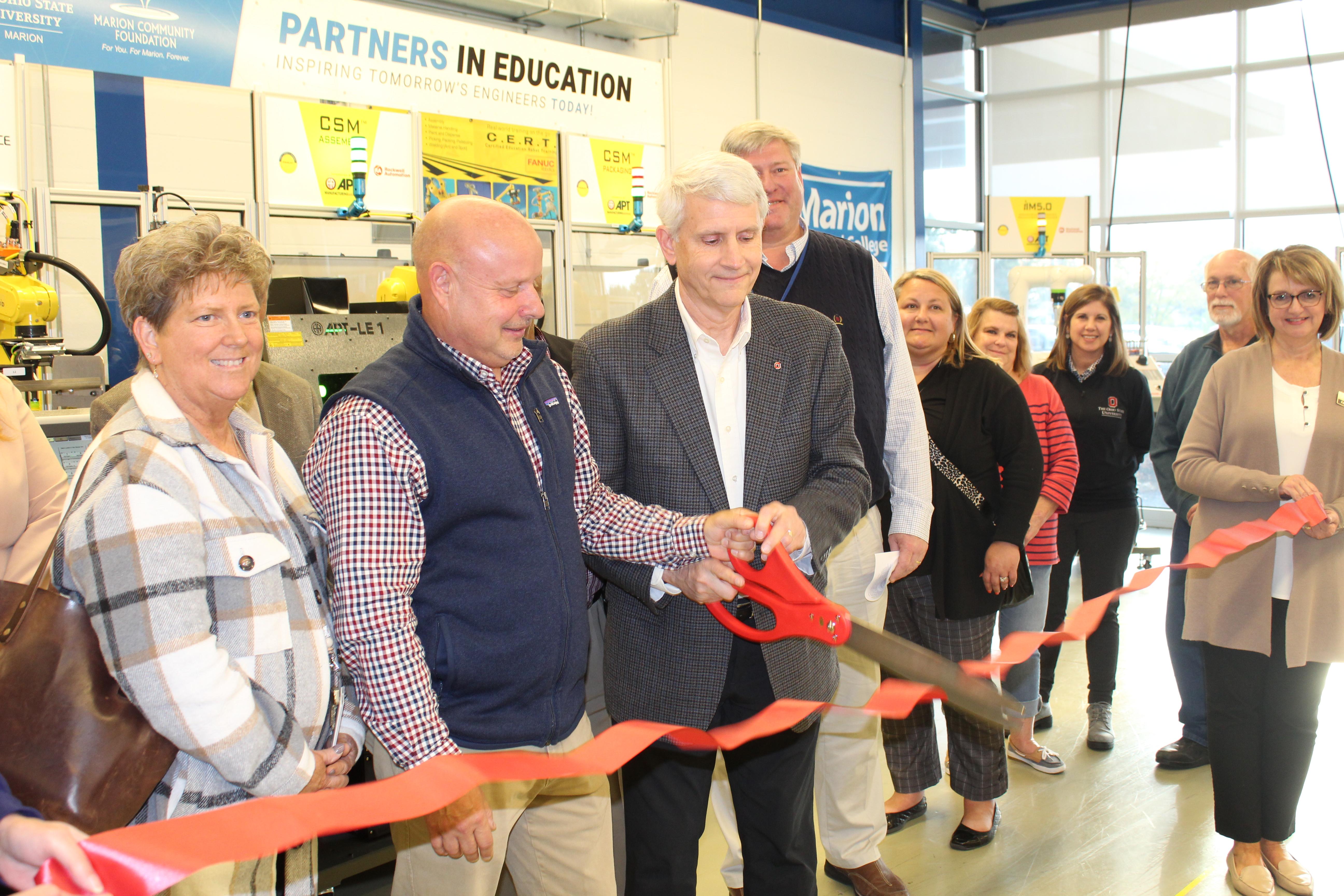 Group of people cutting ribbon at manufacturing education center