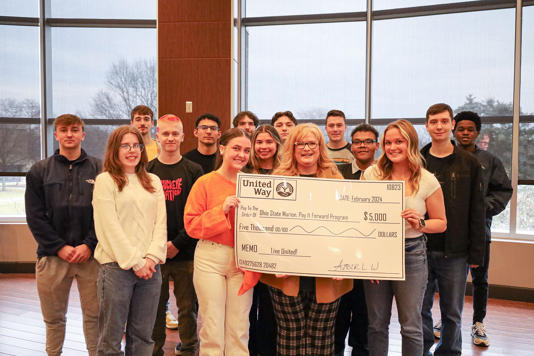 Group of young people holding a giant check