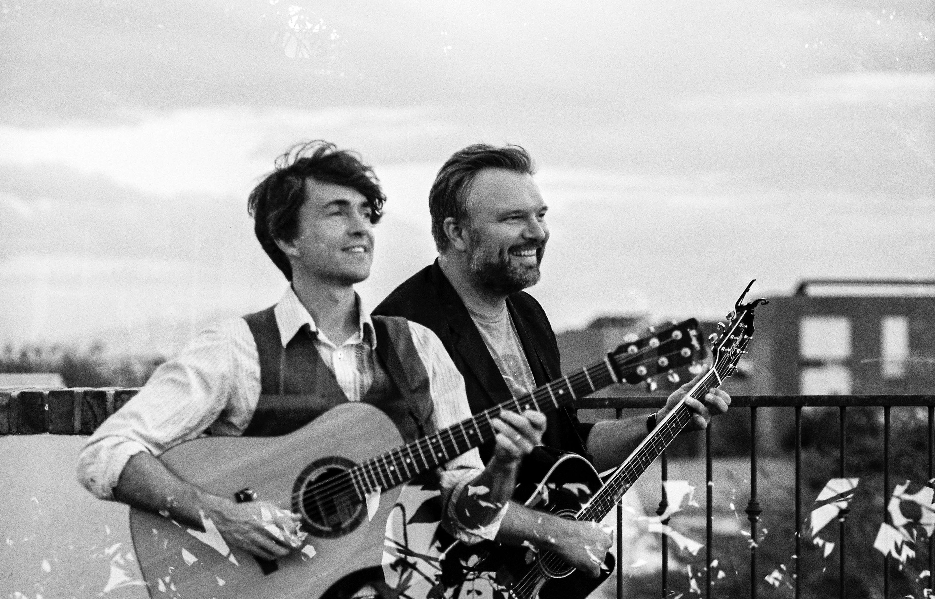 black and whit image of two men with guitars