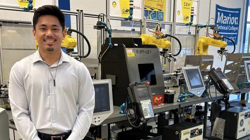 man standing next to engineering manufacturing machine