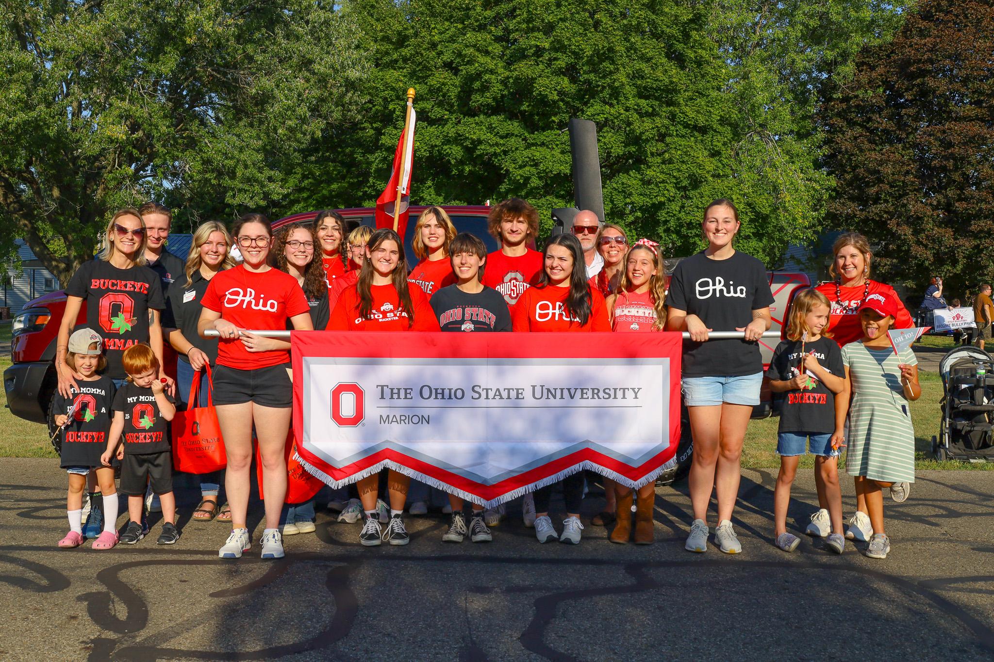 Large group holding college banner