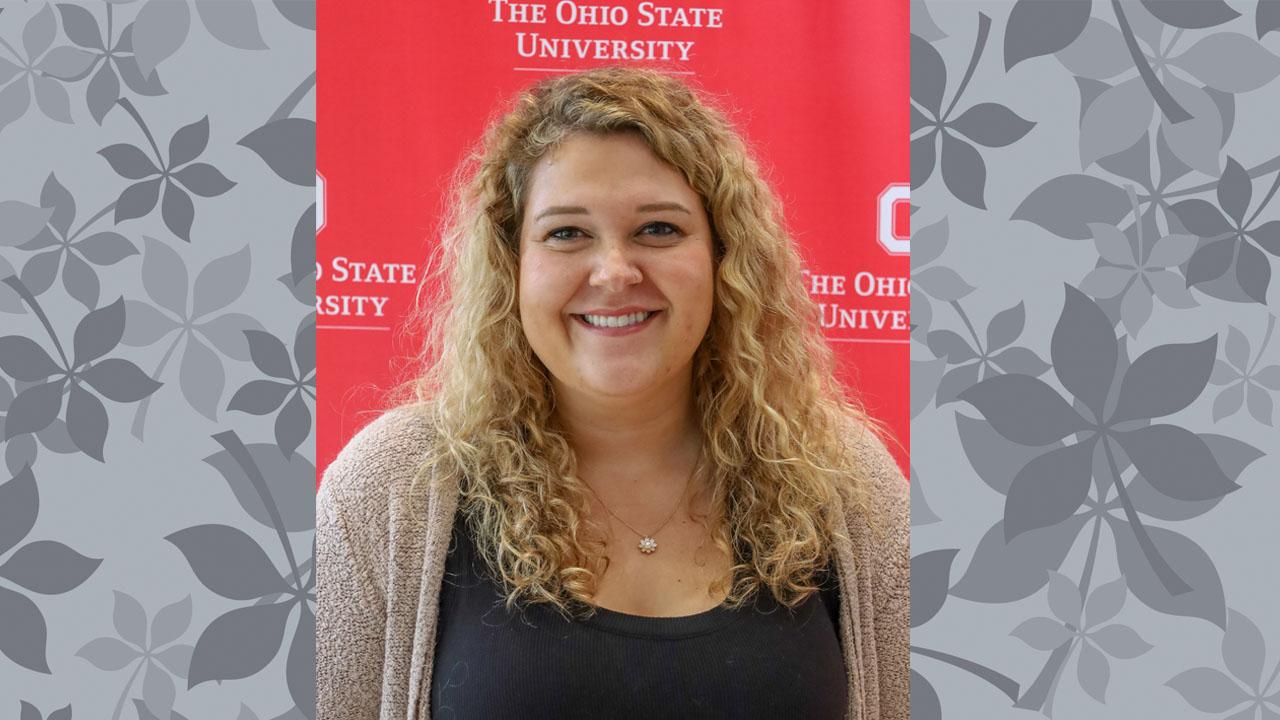 woman in grey sweater with red backdrop