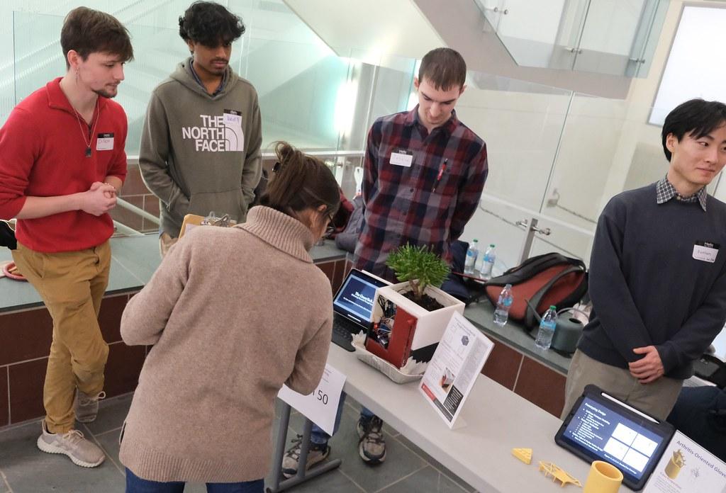 group of young men surrounding table with house plant 