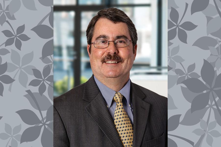 man with glasses and mustache in suit with leaf background