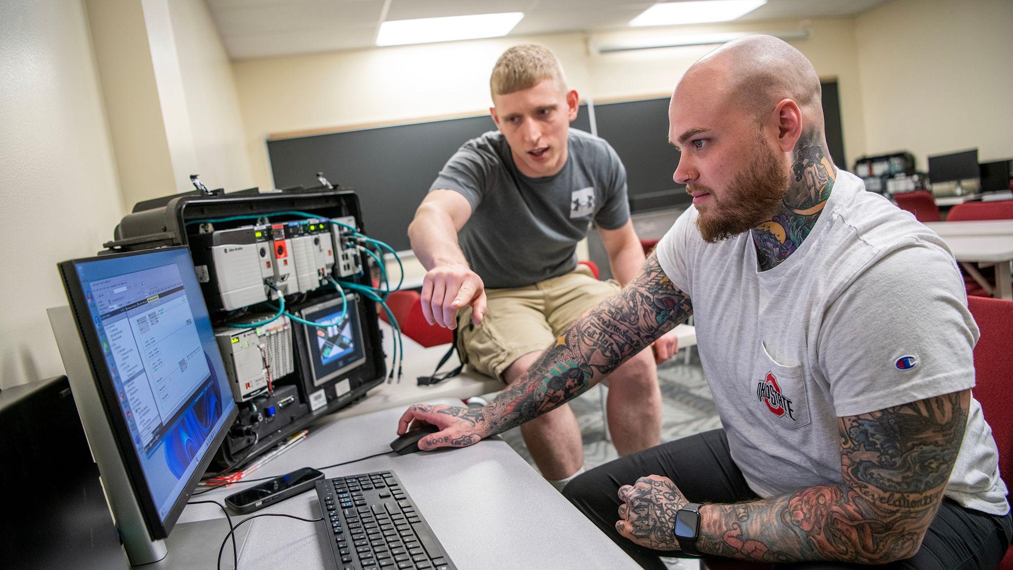two men working with high tech engineering equipment