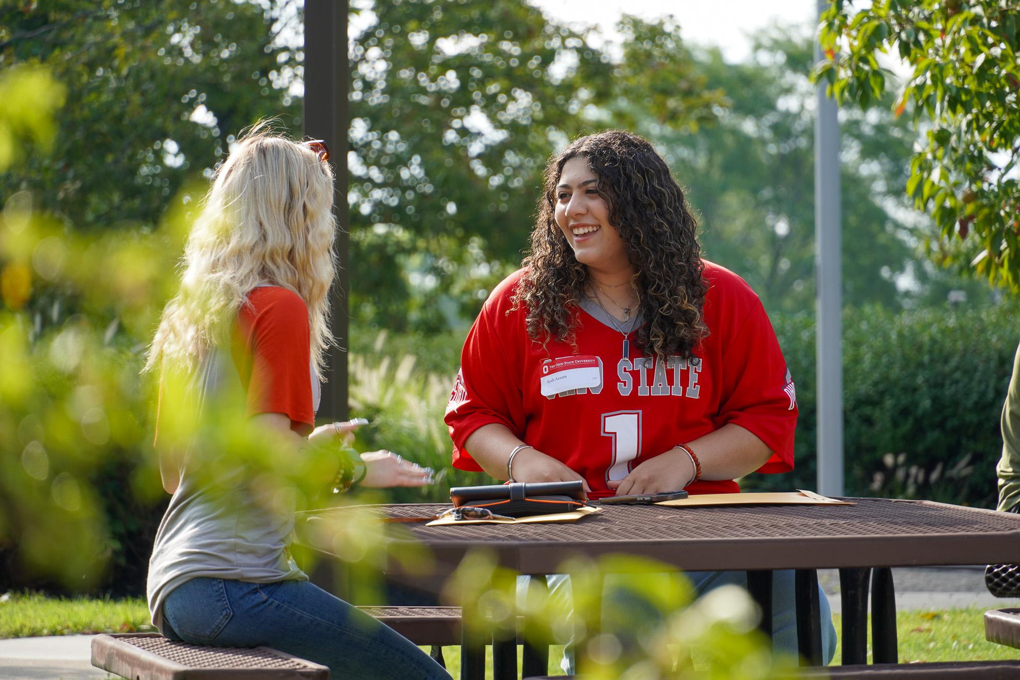 two young women sitting at outdoor table
