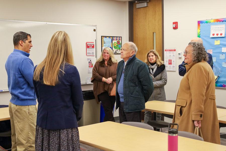 group of seven men and women in conversation in university education classroom