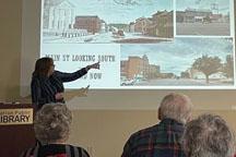 woman giving lecture in front of projection screen