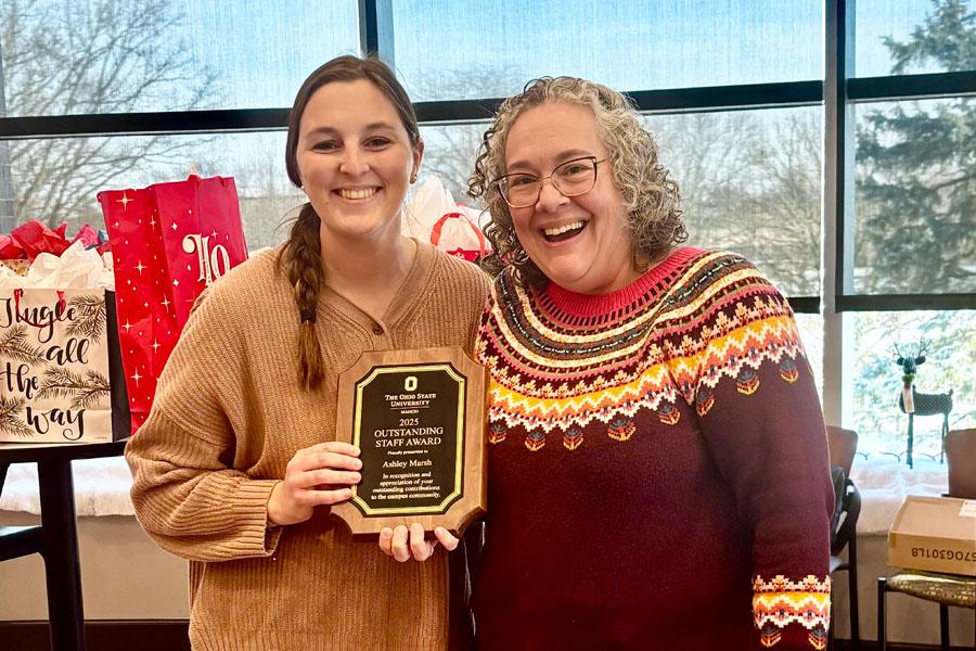 two women holding plaque and smiling