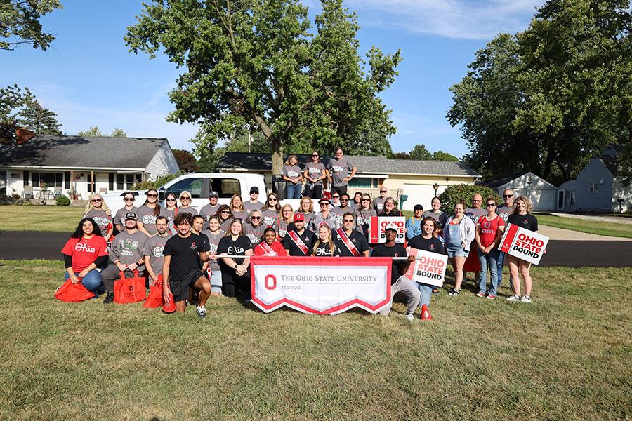 Large group outside with banner in front