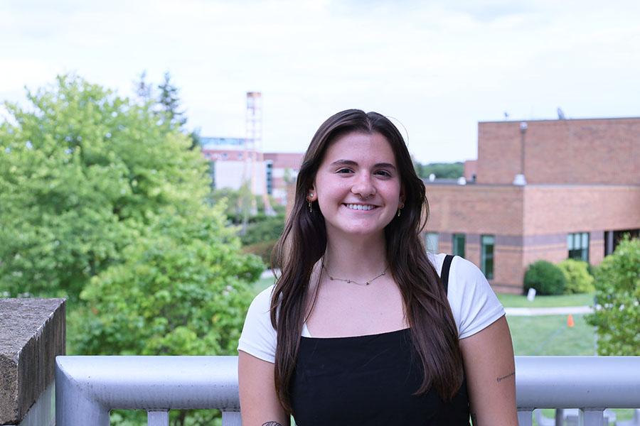 woman on balcony campus in background