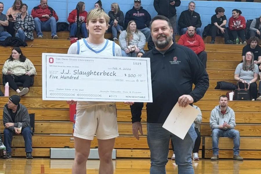 young basketball player presented large scholarship check at half court