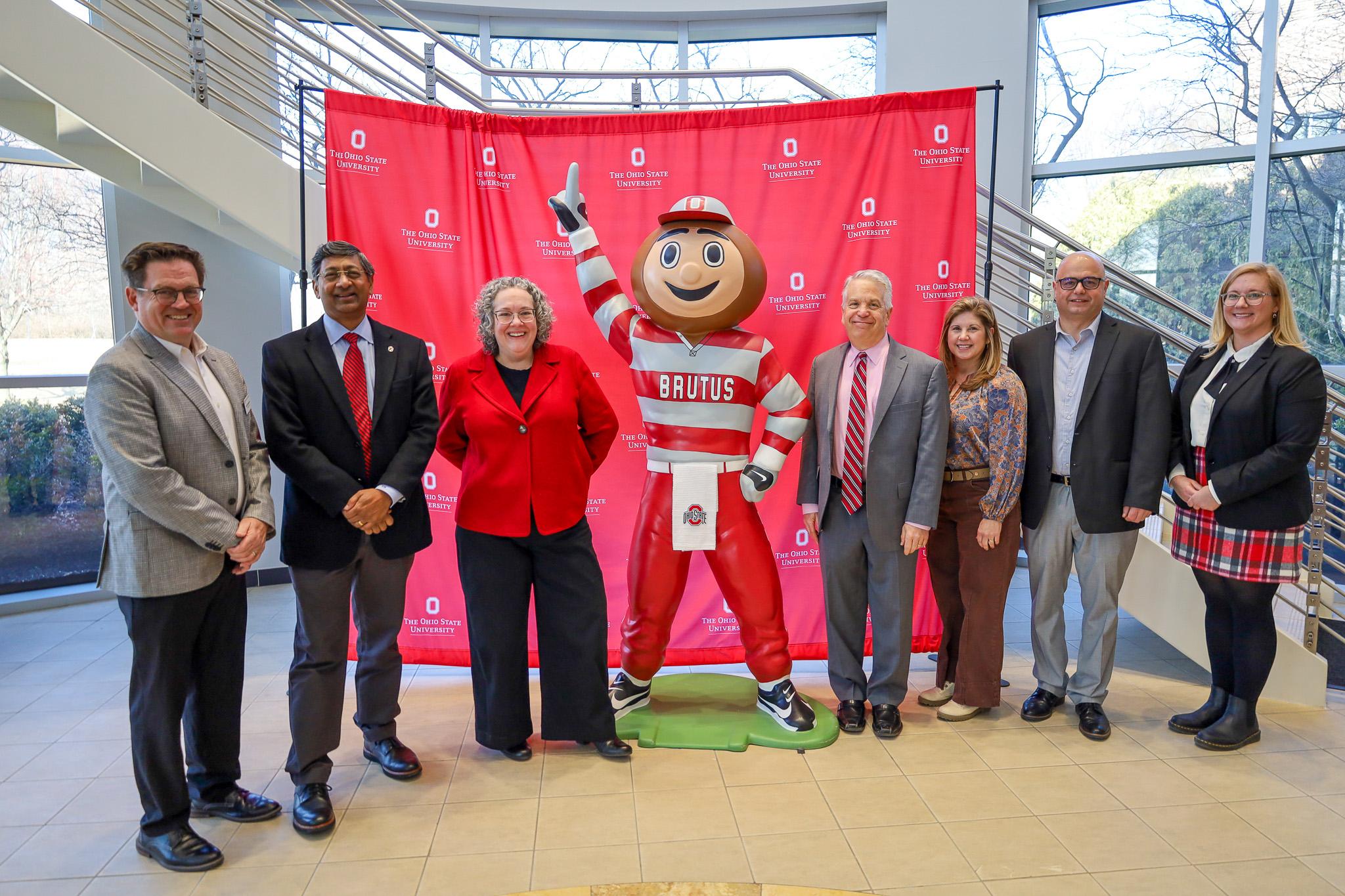 group surrounding Brutus Buckeye statue indoors