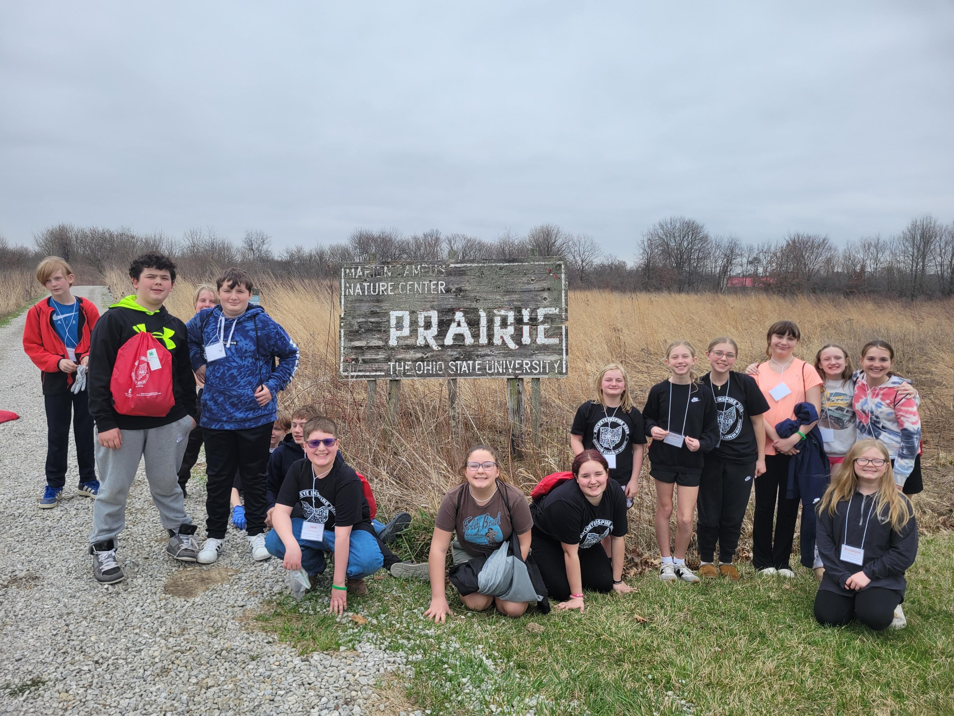 children from a youth camp posing by the prairie sign