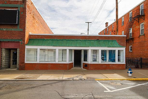 one story building with a green awning set in midwest downtown