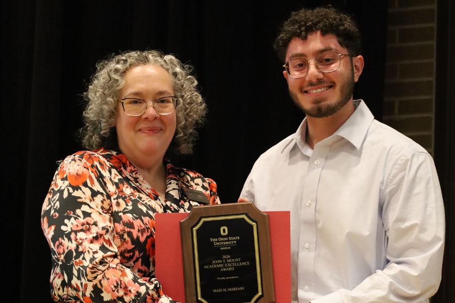 woman and man hold plaque