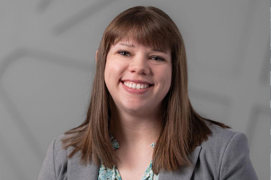 Brunette female grey blazer and gray background