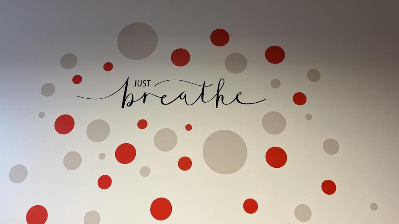 Art on the wall with the words "just breathe"