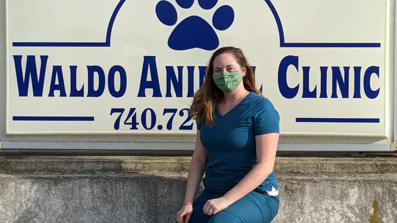 bailey lucas in front of a sign that reads "waldo animal clinic"