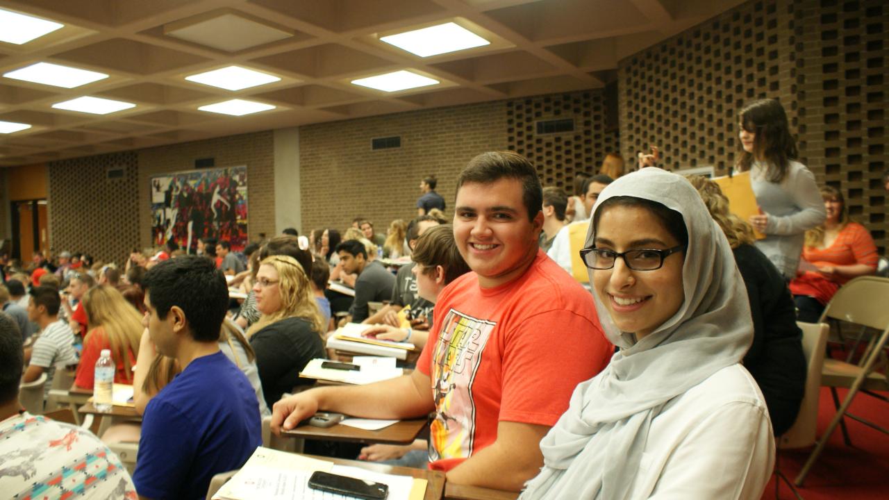 two students smiling in the auditorium