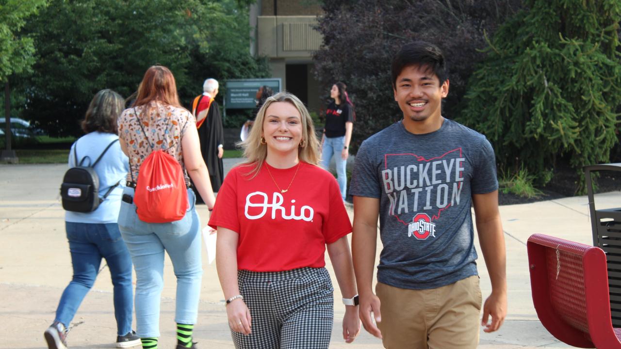 Two college students walking toward camera smiling