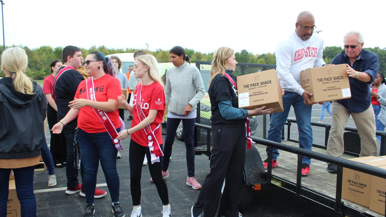 group of people loading boxes onto a flatbed trailer